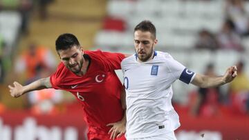 El centrocampista turco Okay Yokuslu disputa un balón ante el centrocampista griego Kostas Fortounis durante un encuentro amistoso entre Turquía y Grecia, este jueves en Antalya, Turquía.
