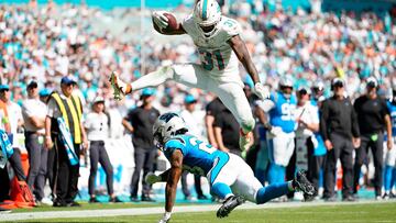 Raheem Mostert #31 of the Miami Dolphins jumps over CJ Henderson #23 of the Carolina Panthers