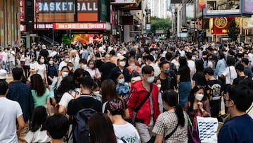 HONG KONG, CHINA - OCTOBER 30: Residents cross an intersection at a shopping district on October 30, 2022 in Hong Kong, China. The world's population is slated to reach 8 billion on November 15, according to the U.N. Hong Kong is one of the densest urban population centers in the world, with its developed areas reaching skyward to house its nearly 7,000 people per square kilometer in slender high rises along narrow tracts of land across the territory. (Photo by Anthony Kwan/Getty Images)