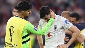 Iran's midfielder #06 Saeid Ezatolahi (R) cries as he is comforted by Iran's goalkeeper #22 Amir Abedzadeh at the end of the Qatar 2022 World Cup Group B football match between Iran and USA at the Al-Thumama Stadium in Doha on November 29, 2022. (Photo by Fadel Senna / AFP)