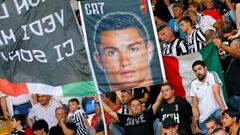Un aficionado de la Juventus sujeta un cartel con la cara de Cristiano Ronaldo.