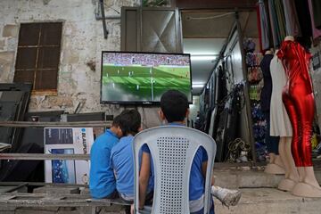 El partido entre Palestina y Arabia Saudí, clasificatorio para el Mundial 2022, levantó una gran expectación, al tratarse de la primera visita de la selección saudita a un estadio de la Cisjordania ocupada. En la imagen, tres niños palestinos ven por televisión el encuentro disputado en Ram, y que terminó con empate a cero.