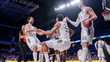 Sergio Llull y Mario Hezonja, este a su manera, ayudan a levantarse del suelo a Edy Tavares, un pívot de 125 kilos. Entre los tres suman 2.195 partidos con el Real Madrid.