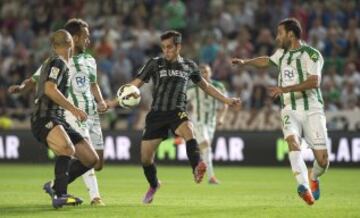 El jugador del Málaga Juanmi se lleva un balón entre Íñigo López y Deivid.