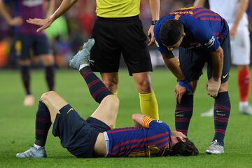 Suárez checks in on his teammate as the referee waves on the medical team.