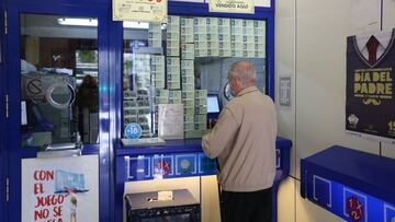 Archivo - Un hombre compra lotería en una administración