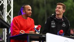 SPIELBERG, AUSTRIA - JULY 09: Lewis Hamilton of Great Britain and Mercedes and George Russell of Great Britain and Mercedes talk on the fan stage prior to practice ahead of the F1 Grand Prix of Austria at Red Bull Ring on July 09, 2022 in Spielberg, Austria. (Photo by Lars Baron - Formula 1/Formula 1 via Getty Images)