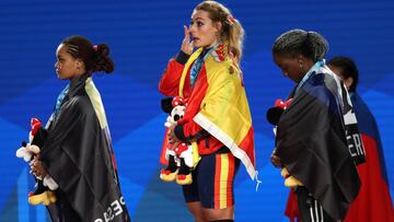 Lydia Valentin se muestra emocionada en el podio junto a Neisi Patricia Dajomes Barrera y Gaelle Verlaine Nayo Ketchanke tras proclamarse campeona del mundo de halterofilia en la categor&iacute;a de 75 kilos en los Mundiales de Anaheim.