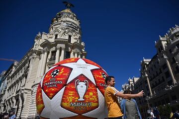 A passerby takes a selfie with a giant replica of the UEFA Champions League ball displayed in Madrid on May 29, 2019 ahead of the final football match between Liverpool and Tottenham Hotspur on June 1. 