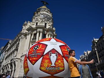 A passerby takes a selfie with a giant replica of the UEFA Champions League ball displayed in Madrid on May 29, 2019 ahead of the final football match between Liverpool and Tottenham Hotspur on June 1. 