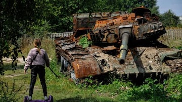 A teenager rides a hoverboard past a destroyed Russian army tank in the village of Lukashivka, Chernihiv region, on September 7, 2022, amid the Russian invasion of Ukraine. (Photo by SERGEI CHUZAVKOV / AFP) (Photo by SERGEI CHUZAVKOV/AFP via Getty Images)