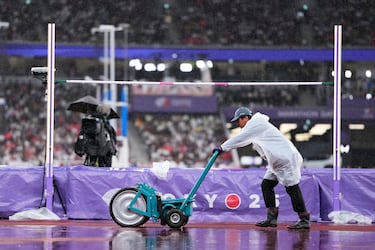 Los voluntarios intentan secar la pista mientras la lluvia retrasa los eventos en el Campeonato Mundial de Atletismo en Tokio.