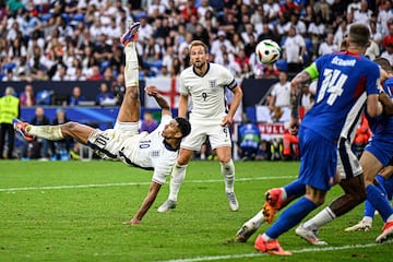 England's midfielder #10 Jude Bellingham (L) shoots an overhead kick to score his team's first goal during the UEFA Euro 2024 round of 16 football match between England and Slovakia at the Arena AufSchalke in Gelsenkirchen on June 30, 2024. (Photo by INA FASSBENDER / AFP)