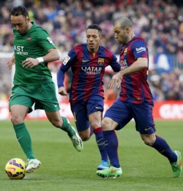 El centrocampista del Levante Jordi Xumetra avanza con el balón ante los jugadores del FC Barcelona, el brasileño Adriano Correia y el argentino Javier Mascherano, durante el partido de la vigésimo tercera jornada de liga de Primera División.