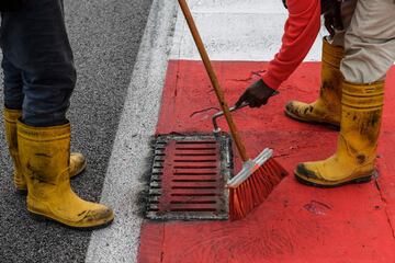 Los operarios del circuito de Sepang arreglan la alcantarilla que provocó el accidente del piloto francés.