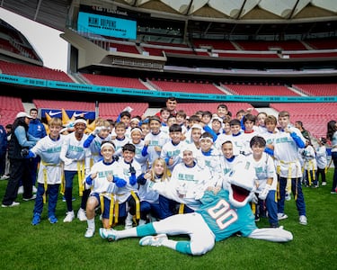 El defensor Atlético, Marc Pubill, posa con jóvenes seguidores de los Miami Dolphins.