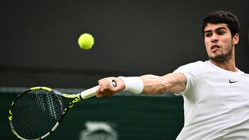 Spain's Carlos Alcaraz returns the ball to France's Jeremy Chardy  during their men's singles tennis match on the second day of the 2023 Wimbledon Championships at The All England Tennis Club in Wimbledon, southwest London, on July 4, 2023. (Photo by SEBASTIEN BOZON / AFP) / RESTRICTED TO EDITORIAL USE