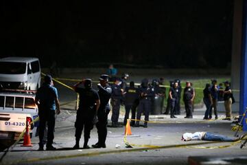 IM?GENES SENSIBLES. Miembos de la polic¨ªa salvadore?a crean un per¨ªmetro junto al cuerpo de una persona fallecida durante la avalancha en el Estadio Coscutl¨¢n.