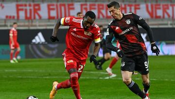 Union Berlin's Dutch forward Sheraldo Becker (L) and Bayern Munich's Polish forward Robert Lewandowski vie for the ball during the German first division Bundesliga football match 1 FC Union Berlin vs FC Bayern Munich in Berlin, on December 12, 2