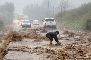 Un residente local limpia las rocas que fueron arrastradas por las aguas rápidas hacia un tramo de la carretera inundada en las afueras de Boone, Carolina del Norte.