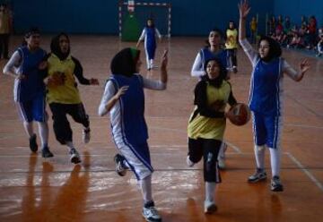 Las jugadoras de baloncesto afganas de la provincia de Herat (en amarillo) compiten con el equipo de Kabul, en un partido amistoso en el Estadio Olímpico Nacional de Kabul el 18 de septiembre de 2013.