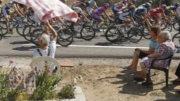 <b>RESPALDO. </b>Varios aficionados, plácidamente sentados en la cuneta, saludan el paso del pelotón, que en la jornada de ayer se adentró por Tierra de Campos.