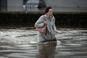 Una mujer intenta caminar a través del agua después de las fuertes lluvias en Ciaran, en el centro de la ciudad de Newry, Irlanda del Norte.