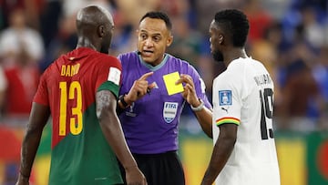 US referee Ismail Elfath (C) shows a yellow card to Portugal's defender #13 Danilo Pereira (L) and Ghana's forward #19 Inaki Williams (R) during the Qatar 2022 World Cup Group H football match between Portugal and Ghana at Stadium 974 in Doha on November 24, 2022. (Photo by Khaled DESOUKI / AFP)