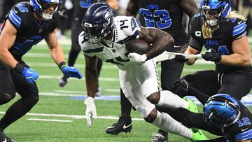 Sep 30, 2024; Detroit, Michigan, USA; Seattle Seahawks wide receiver DK Metcalf attempts to break multiple tackles against the Detroit Lions in the first quarter at Ford Field. Mandatory Credit: Eamon Horwedel-Imagn Images