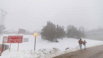 Dos personas caminan por una pista forestal en el Puerto de Navacerrada, a 1 de diciembre de 2021, en Cercedilla, Madrid (España). La apertura de Navacerrada para este invierno es todavía una incógnita y la estación se ha convertido en motivo de conflicto