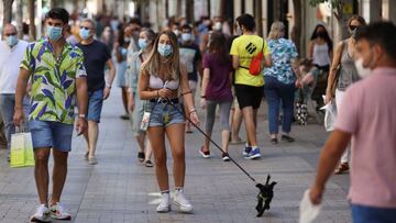 Imagen de varias personas caminando por la calle y portando mascarillas.