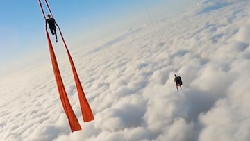 Timothy Parrant y Daniela Dragan en el aire, sobre las nuves, con telas acrob&aacute;ticas colgando de un globo aerost&aacute;tico.