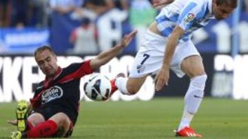 El centrocampista del M&aacute;laga Joaqu&iacute;n S&aacute;nchez pelea un bal&oacute;n con el defensa del Deportivo Ayoze D&iacute;az, durante el partido de la trig&eacute;sima s&eacute;ptima jornada de Liga de Primera Divisi&oacute;n que se disputa esta noche en el estadio de La Rosaleda. 