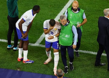 Kylian Mbappé se retira lesionado del campo por el fuerte impacto que recibe en la nariz.