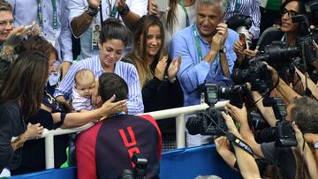 Michael Phelps saluda a su novia Nicole Johnson y su madre Debbie Phelps y besa a su hijo de tres meses Boomer Phelps tras recibir la medalla de oro de campeón de 200 metros mariposa de los Juegos Olímpicos de Río.