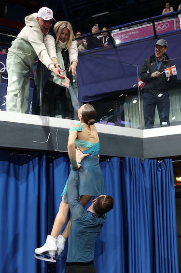 Las medallistas de plata Anastasiia Metelkina y su compañero Luka Berulava, del equipo de Georgia, interactúan con el público tras la ceremonia de entrega de medallas de patinaje libre por parejas. 