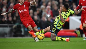 Liverpool's Greek defender #21 Kostas Tsimikas is tackled by Arsenal's Brazilian striker #09 Gabriel Jesus (R) during the English Premier League football match between Liverpool and Arsenal at Anfield in Liverpool, north west England on December 23, 2023. (Photo by Paul ELLIS / AFP) / RESTRICTED TO EDITORIAL USE. No use with unauthorized audio, video, data, fixture lists, club/league logos or 'live' services. Online in-match use limited to 120 images. An additional 40 images may be used in extra time. No video emulation. Social media in-match use limited to 120 images. An additional 40 images may be used in extra time. No use in betting publications, games or single club/league/player publications. / 