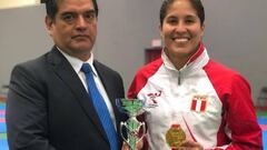 Alexandra  Grande, posando con el oro junto a su entrenador Roberto Reyna.