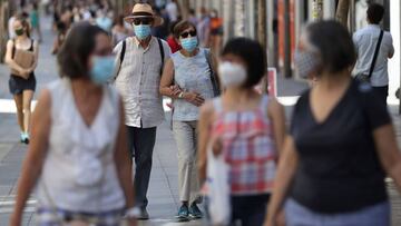 GRAF7941. MADRID, 01/08/2020.- Dos personas con mascarillas caminan por las calles de Madrid este sábado durante la ola de calor. La Agencia Estatal de Meteorología (Aemet) mantiene una treintena de provincias de diez comunidades autónomas en alerta por calor, en nivel naranja -riesgo importante- amplias zonas de Andalucía, Castilla-La Mancha, Cataluña, Madrid, Región de Murcia, Comunidad Valenciana y el archipiélago balear, por valores superiores a 40 grados. EFE/ Mariscal