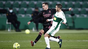 ELCHE, SPAIN - DECEMBER 30: Lucas Vazquez of Real Madrid shoots under pressure from Victor Rodriguez of Elche during the La Liga Santander match between Elche CF and Real Madrid at Estadio Martinez Valero on December 30, 2020 in Elche, Spain. Sporting sta