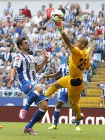El portero de la UD Almería Rubén Martínez (d) despeja el balón ante el delantero portugués del Deportivo de la Coruña Helder Postiga (i), durante el partido de la sexta jornada de Liga de Primera División, disputado esta tarde en el estadio de Riazor.