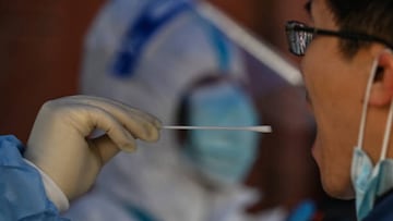 A man is tested for the Covid-19 coronavirus at a residential compound in Shanghai on March 18, 2022. (Photo by Hector RETAMAL / AFP) (Photo by HECTOR RETAMAL/AFP via Getty Images)