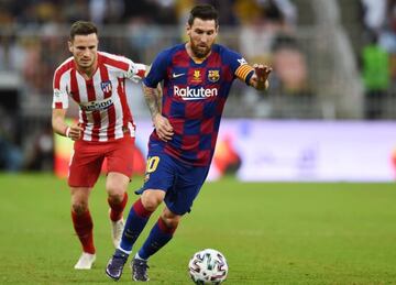 Barcelona's Lionel Messi (R) and Atletico Madrid's Saul Niguez battle for the ball during the Spanish Supercopa