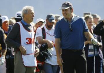 Clint Eastwood charla con Nick Faldo.