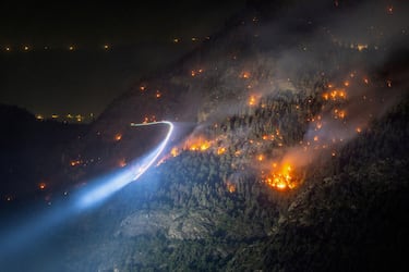 Vista general de un incendio forestal en el lateral de una montaña de los Alpes cerca de la localidad de Bitsch, cantón de Valais, Suiza. Fotografía tomada con una exposición prolongada.
