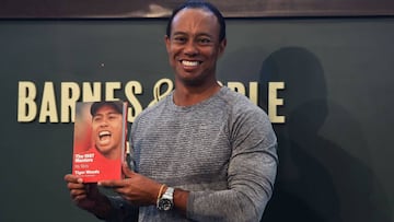 The 14-time major champ golfer Tiger Woods holds a copy of his new book "The 1997 Masters: My Story" before his booking signing at Barnes & Noble's Union Square in New York on March 20, 2017. / AFP PHOTO / TIMOTHY A. CLARY