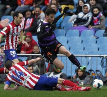 Los jugadores del Atlético de Madrid Juanfran, y Gabi, disputan el balón con el jugador del Valladolid Omar, durante el partido correspondiente a la vigésimo cuarta jornada de liga de Primera División disputado esta tarde en el estadio Vicente Calderón.