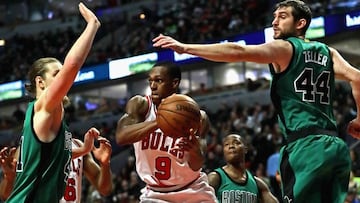 Rajon Rondo, durante su etapa con los Chicago Bulls, traspasa la defensa de Kelly Olynyk y Tyler Zeller.