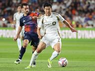 Feb 28, 2026; Houston, Texas, USA; Los Angeles FC forward Son Heung-Min (7) attempts to control the ball as Houston Dynamo FC midfielder Agustín Bouzat (30) defends during the first half at Shell Energy Stadium. Mandatory Credit: Troy Taormina-Imagn Images