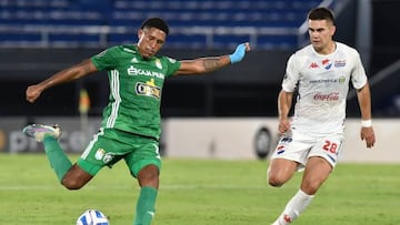 Sporting Cristal's midfielder Jesus Castillo (L) strikes the ball as Nacional's forward Cristhian Ocampos looks on during their Copa Libertadores second round first leg football match between Paraguay's Nacional and Peru's Sporting Cristal, at the Defensores del Chaco stadium in Asuncion, on February 21, 2023. (Photo by NORBERTO DUARTE / AFP) (Photo by NORBERTO DUARTE/AFP via Getty Images)